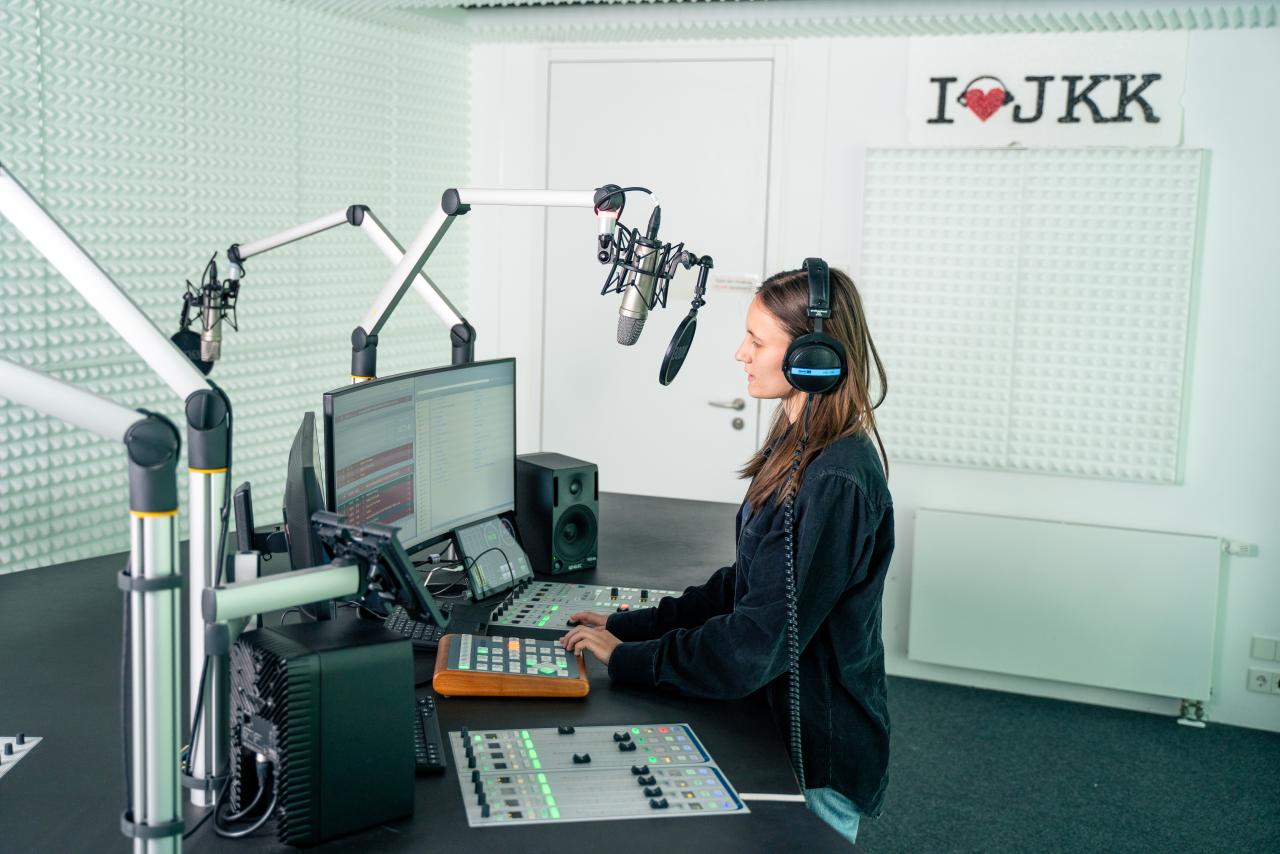 Studentin moderiert eine Radio Sendung im Sendestudio