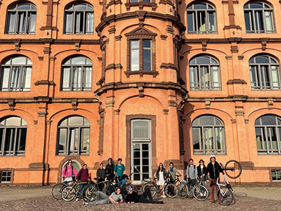 Studierende mit Fahrrädern vor dem Gottesauer Schloss